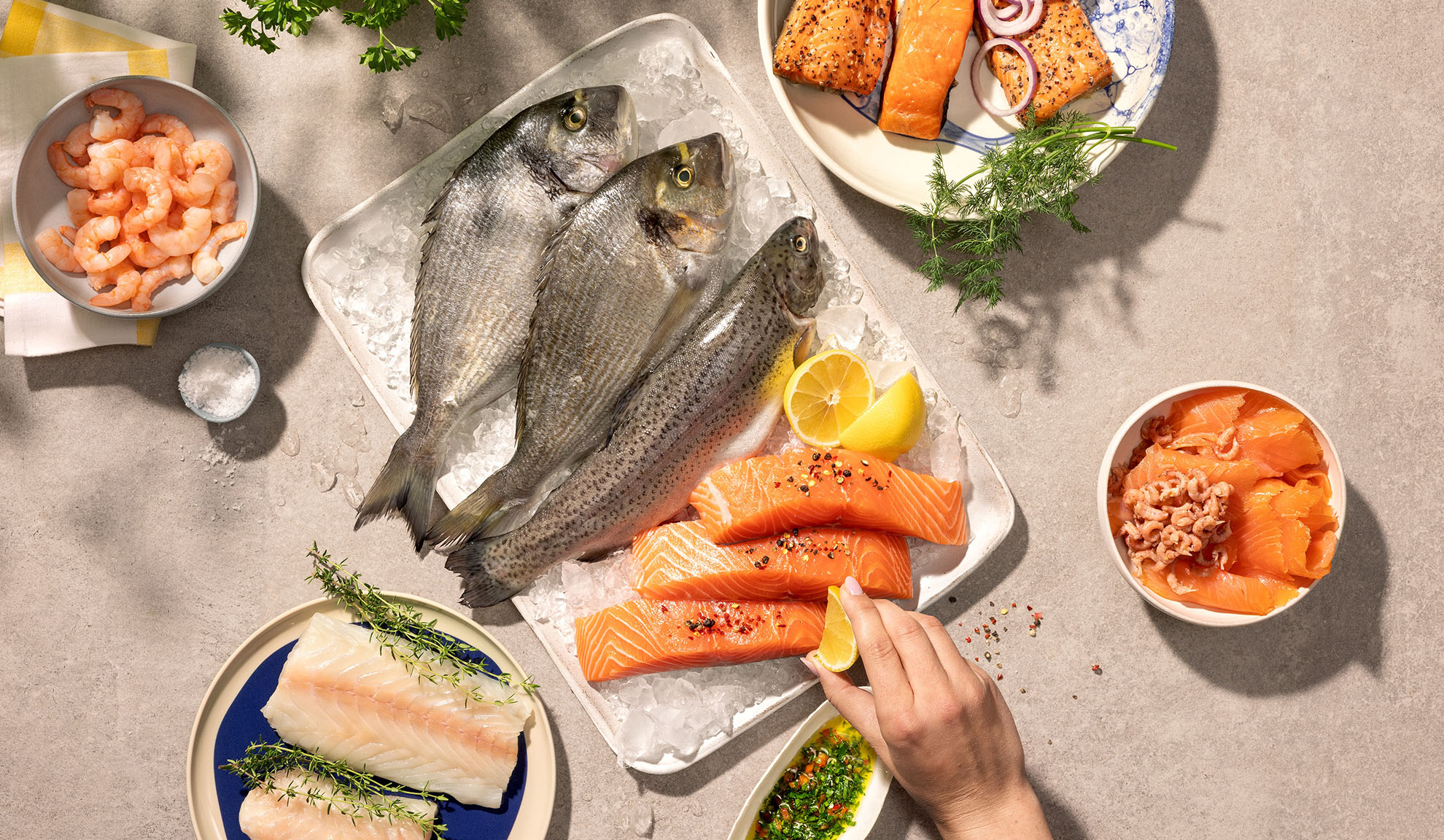 Assorted fresh seafood, including fish, salmon, and shrimp, ready for cooking.