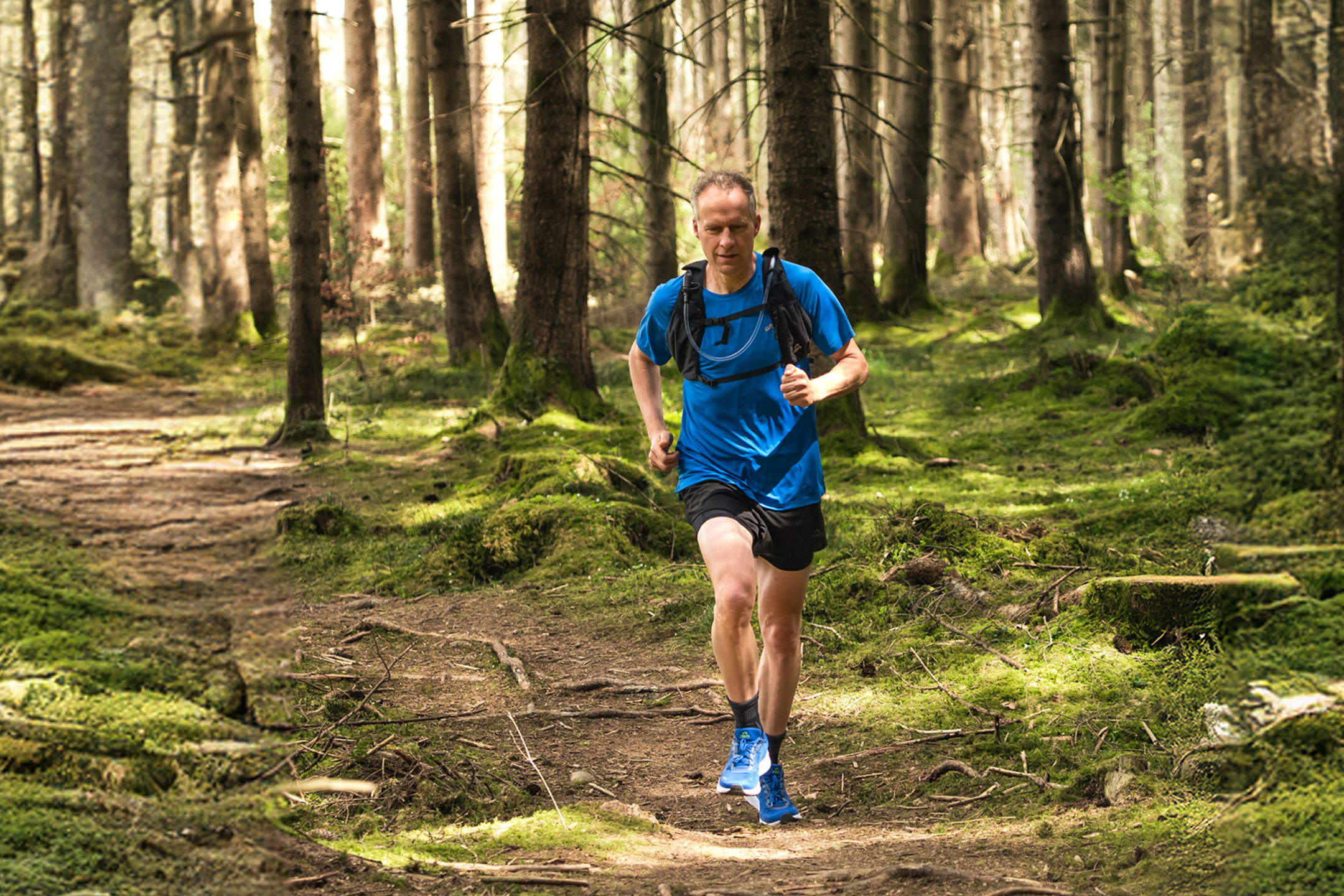 Trail running: homem correndo na floresta.