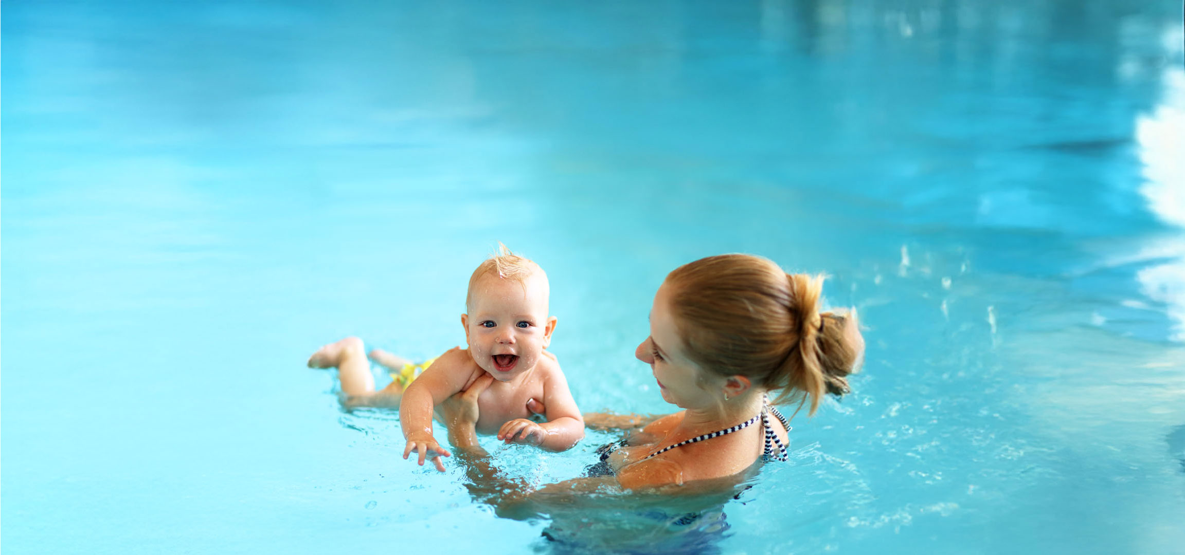 Mãe e bebê nadando na piscina.