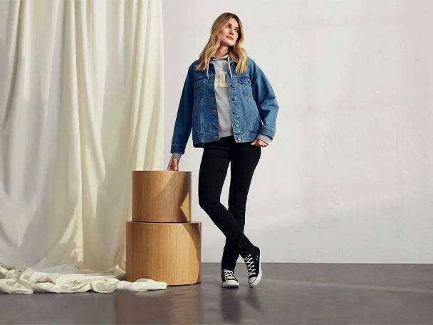 Jeansjacka, jeans och träbord.