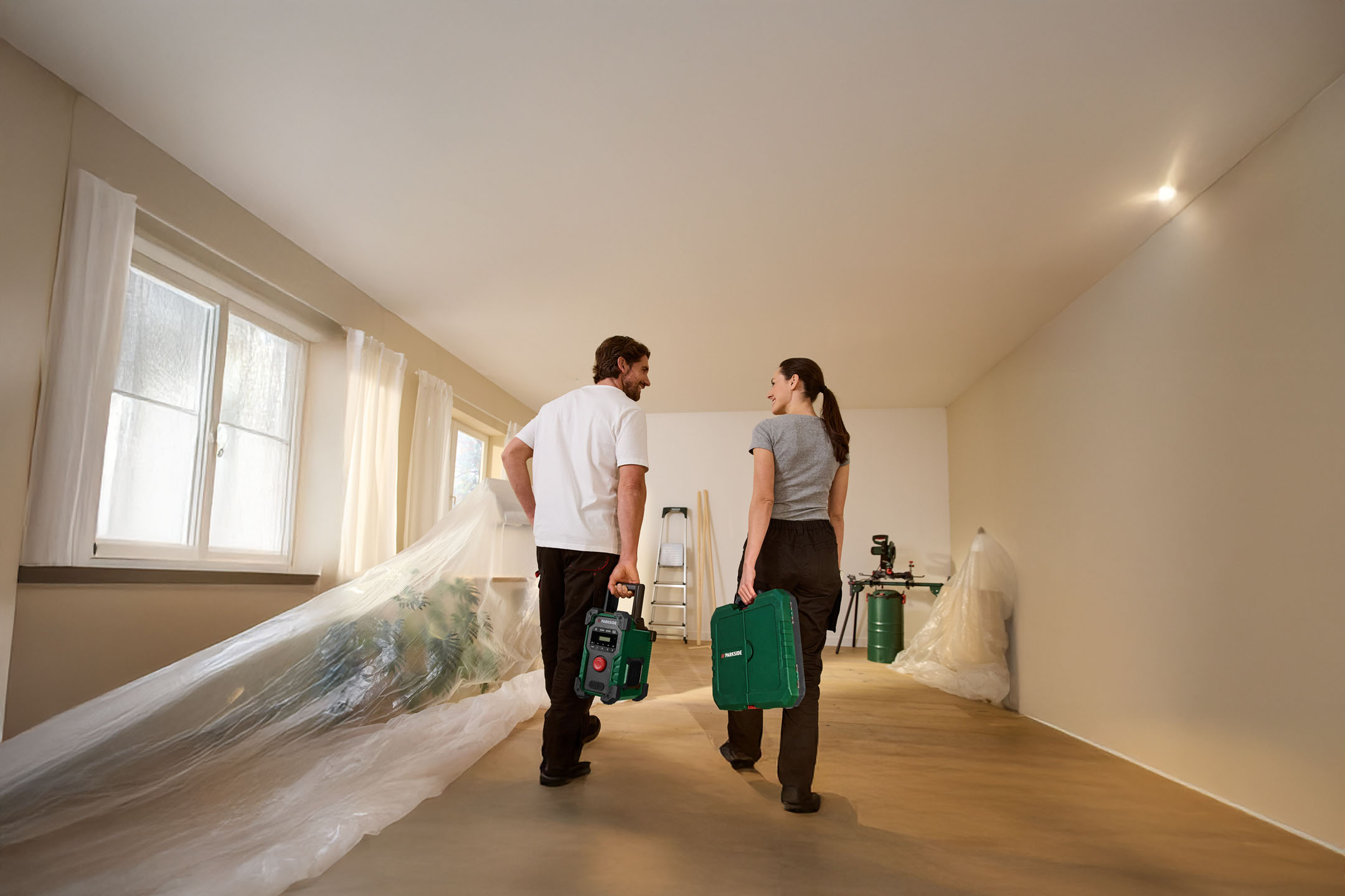 Casal com ferramentas Parkside numa casa em renovação.