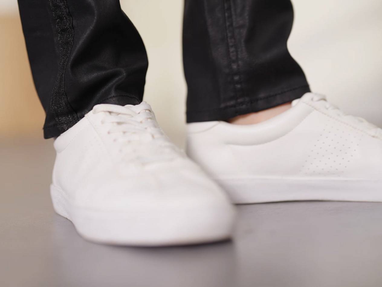 Vita sneakers med svarta byxor.