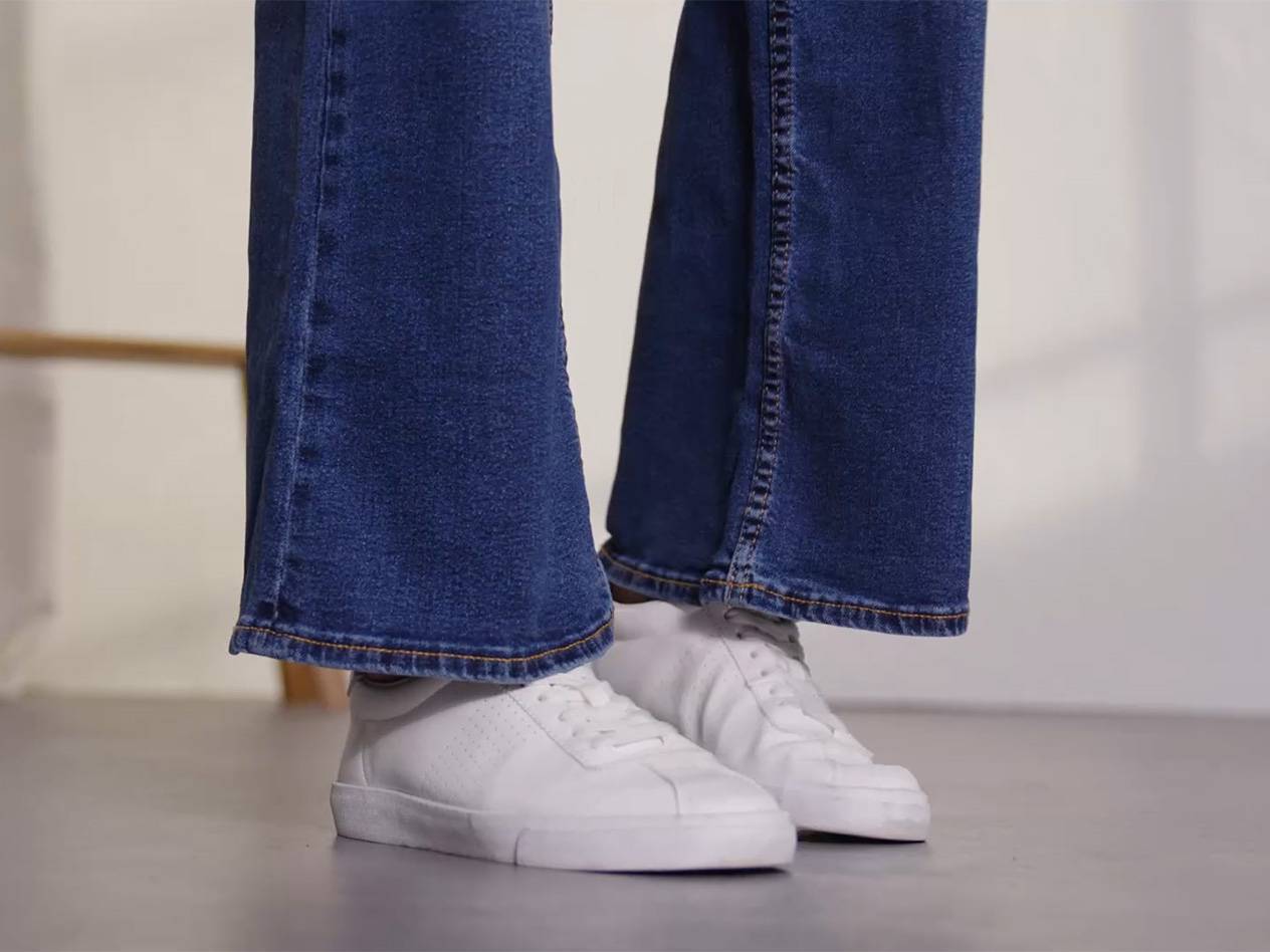 BlĂĄ jeans och vita sneakers.